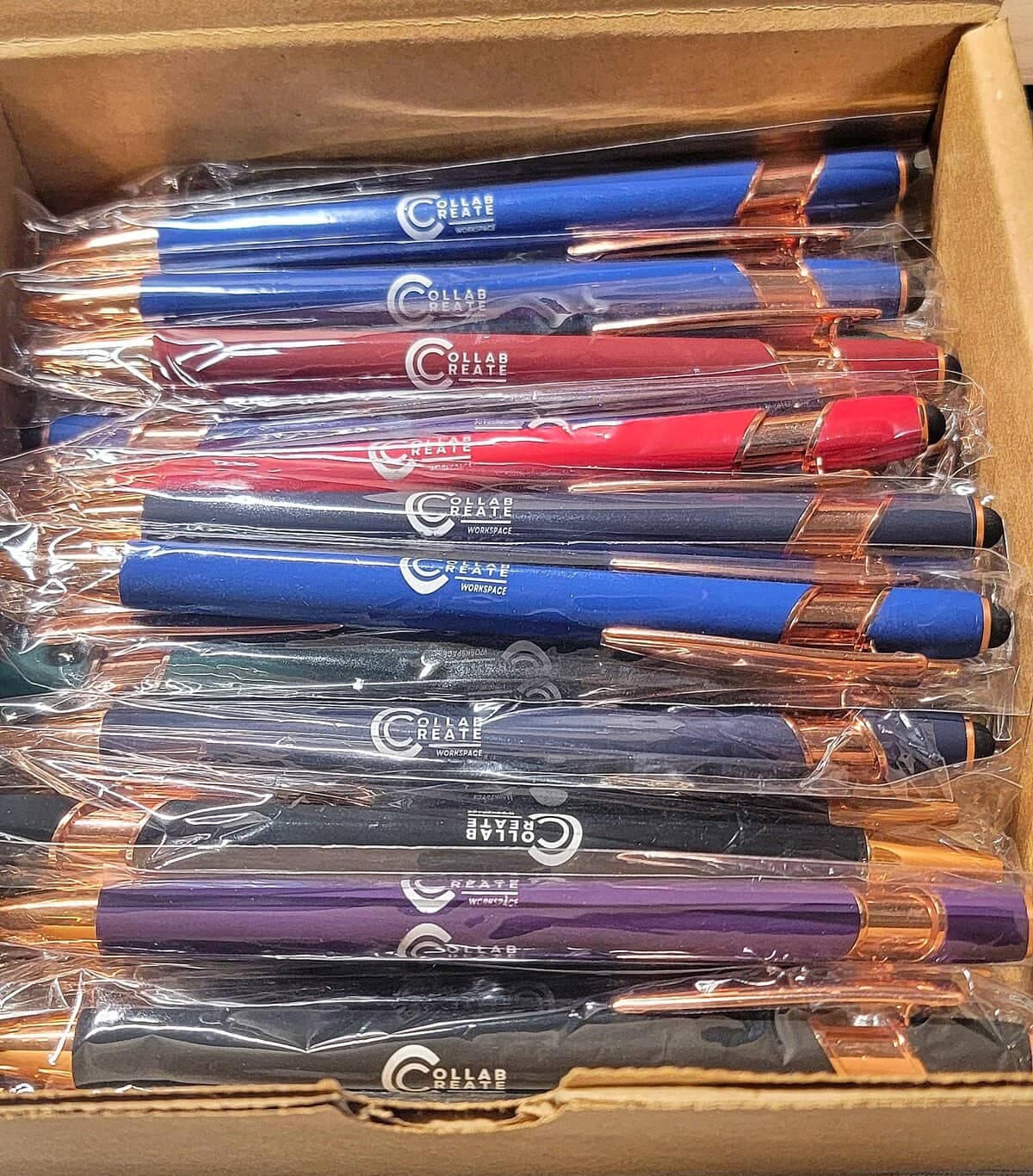 Box of custom logo stylus pens in assorted colors, individually bagged