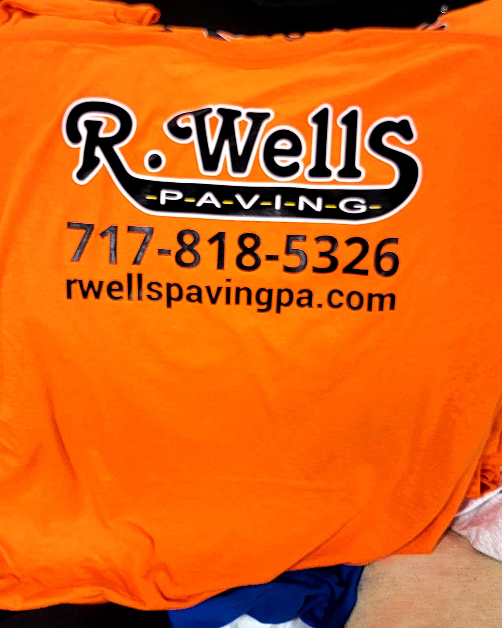 Two-color company logo printed on a safety-orange t-shirt