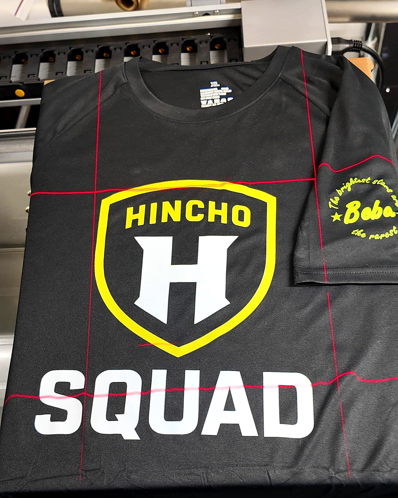 Black team t-shirt with a shield logo on the front and a sleeve print