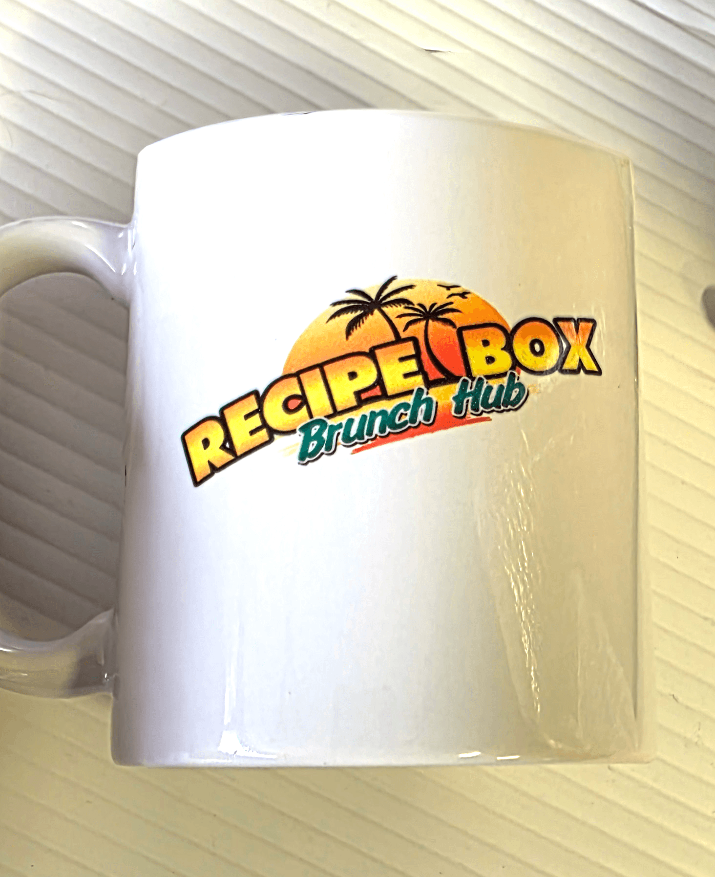 White ceramic coffee mug with a full-color sublimated Recipe Box Brunch Hub logo — dye sublimation at Print Habit, Coatesville PA