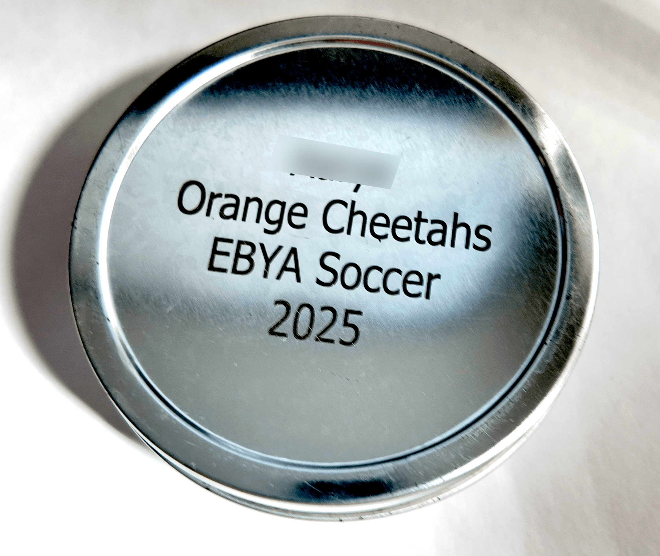 Laser-engraved personalized presentation tin for a youth soccer team medal by Print Habit