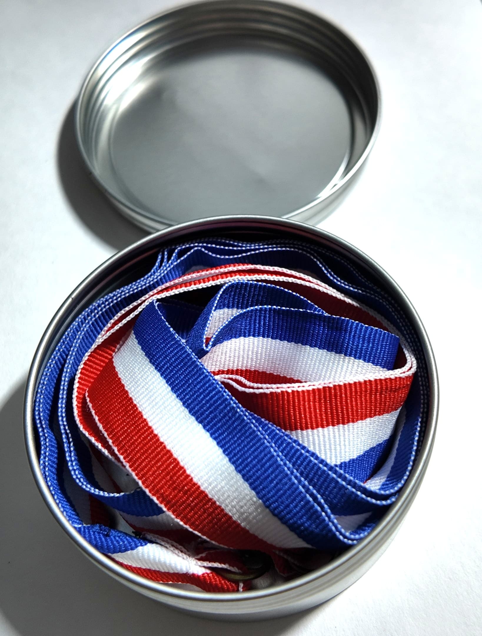 Custom soccer medals with red-white-blue ribbons in a presentation tin by Print Habit