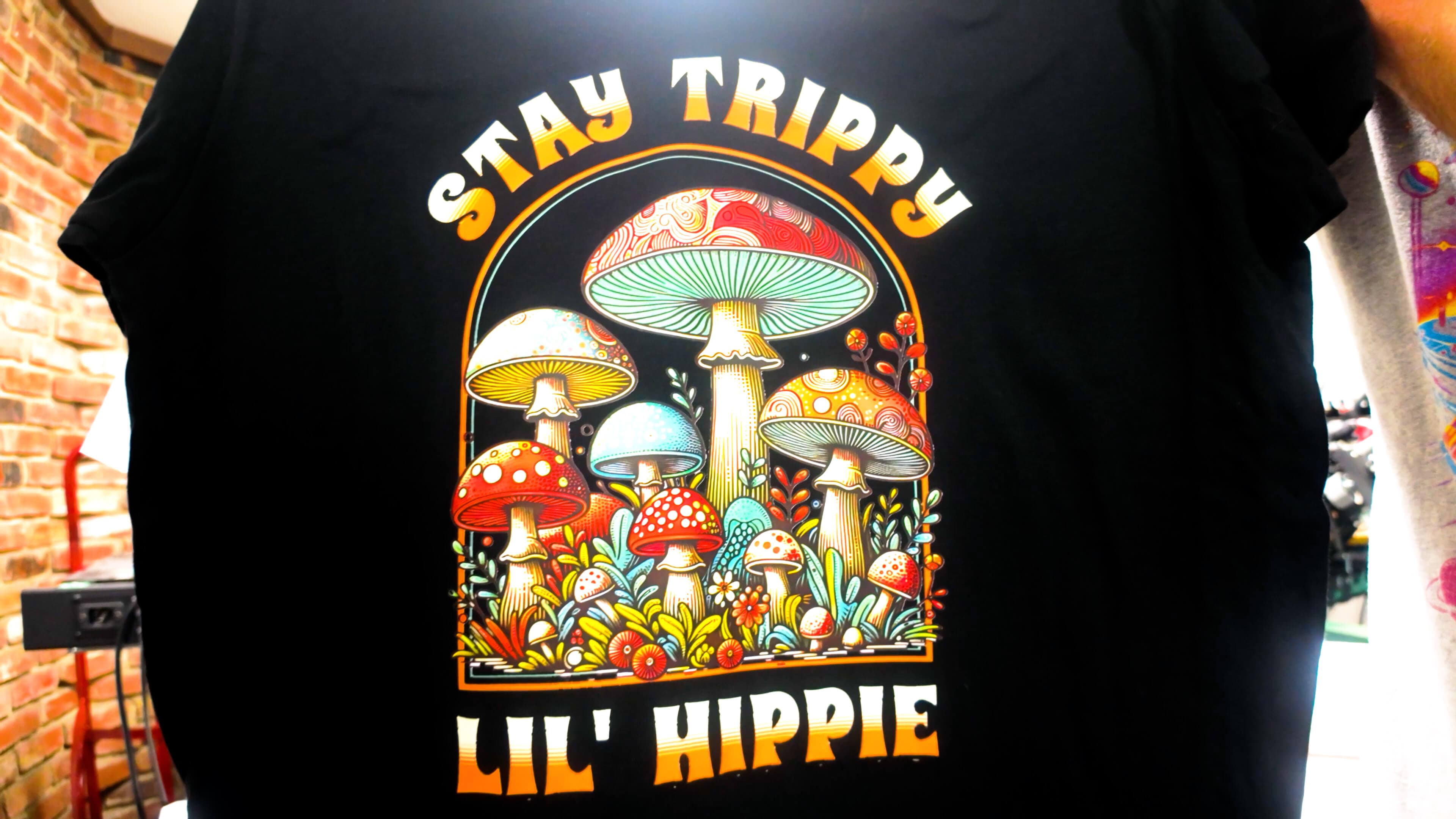 'Stay Trippy Lil' Hippie' full-color mushroom DTF print on a black t-shirt — Print Habit, Coatesville PA
