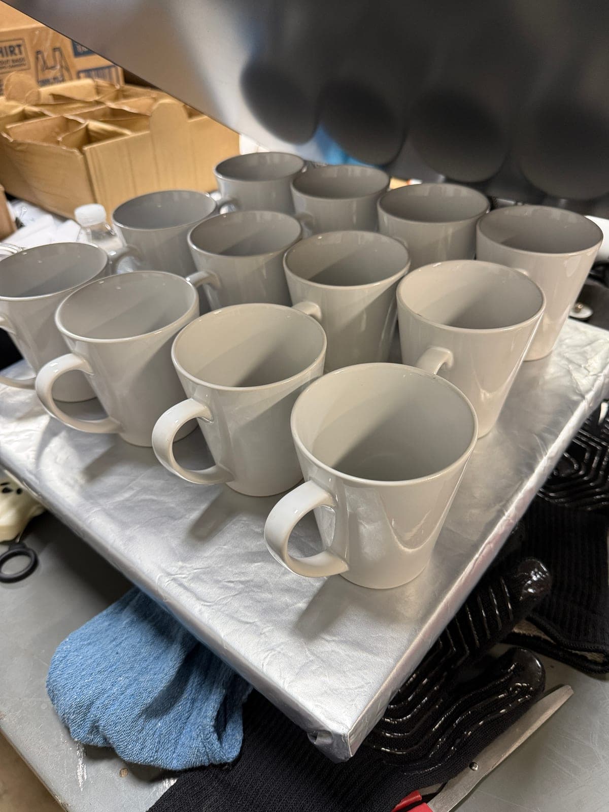 Rows of blank white ceramic latte mugs lined up and ready for sublimation