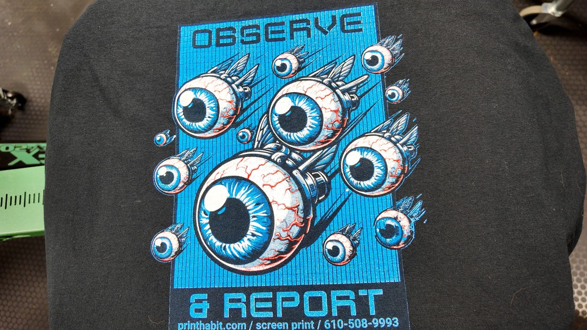 Bold 'Observe & Report' flying-eyeballs design screen printed on a dark t-shirt by Print Habit, Coatesville PA