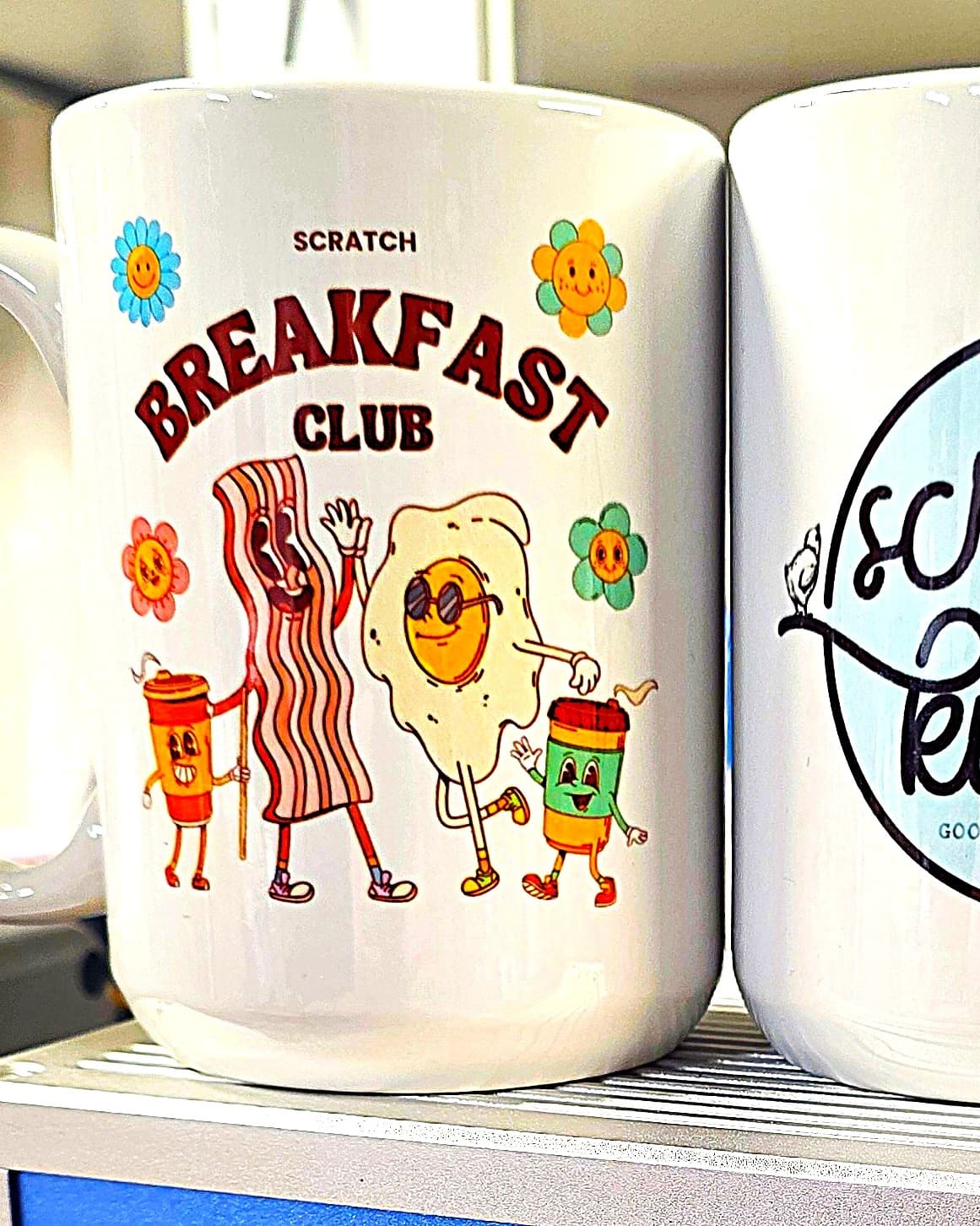 White sublimated mug with a full-color Scratch Kitchen Breakfast Club design